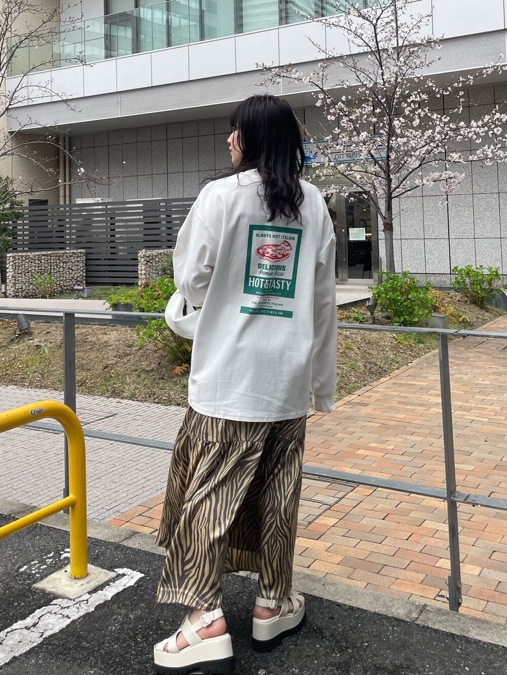 ホワイト系のTシャツ/カットソー、ベージュ系のスカート、ホワイト系のハンドバッグを着用したレディースの春コーディネートの3枚目の写真