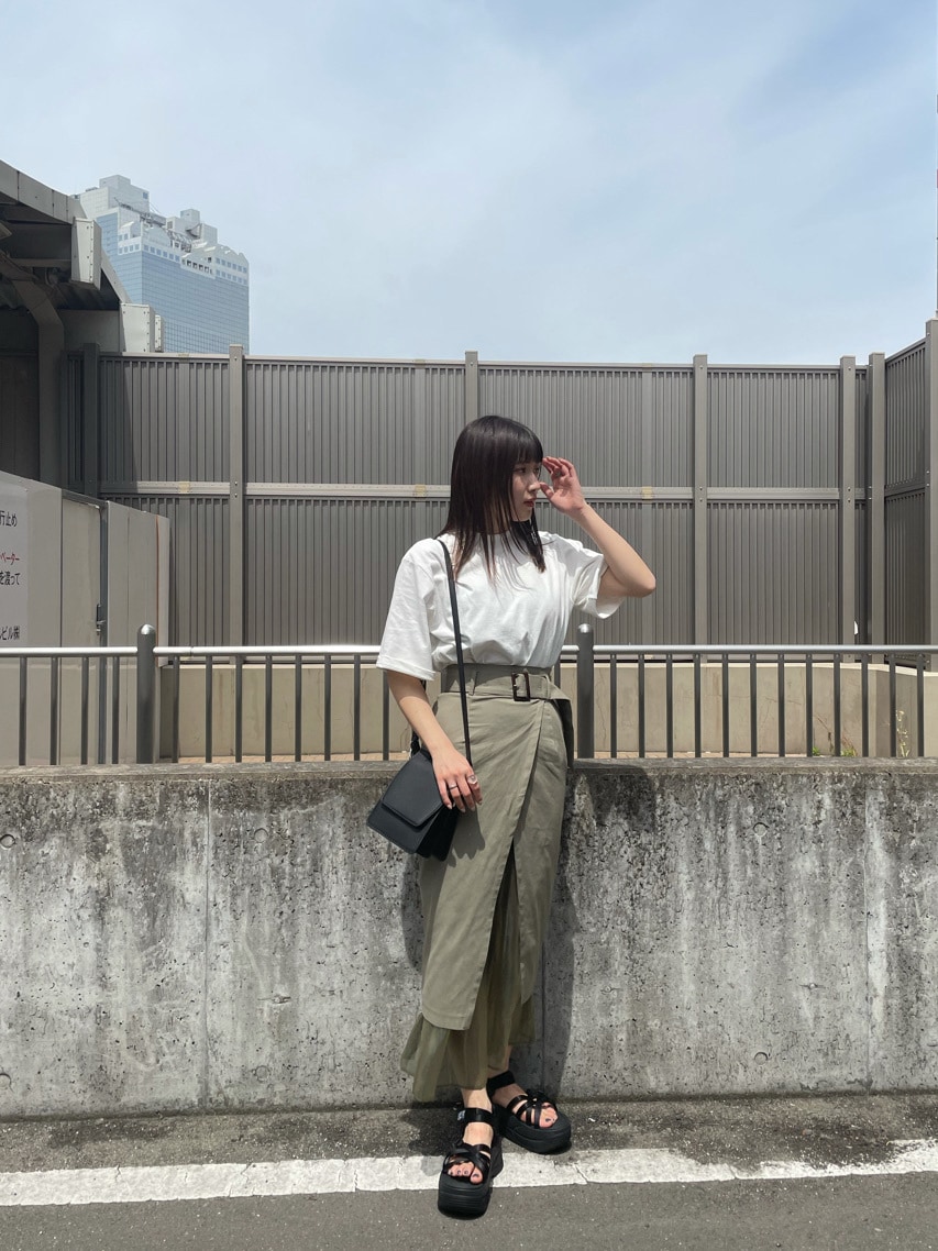 ベージュ系のスカート、ブラック系のサンダル、ホワイト系のTシャツ/カットソーを着用したレディースの春コーディネートの2枚目の写真