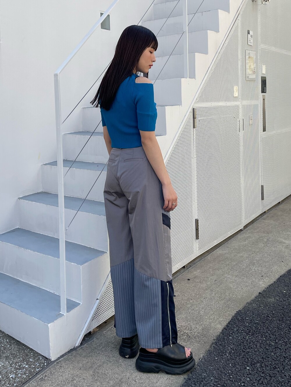 グレー系のその他パンツ、ブルー系のニット/セーターを着用したレディースの夏コーディネートの2枚目の写真
