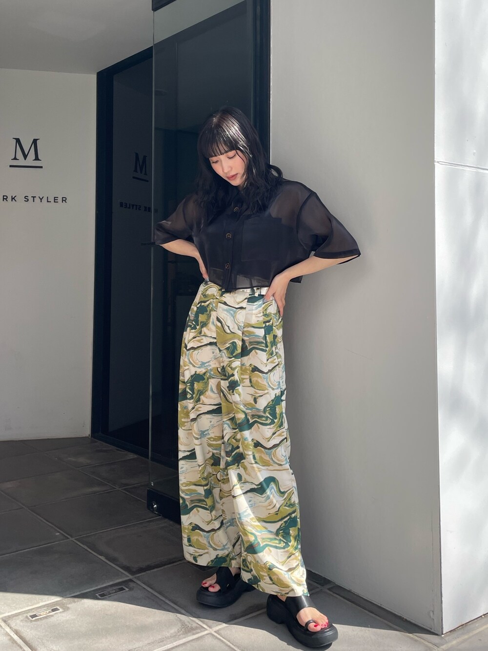 ブラック系のシャツ/ブラウス、グリーン系のスラックス、ブラック系のサンダルを着用したレディースの春コーディネートの4枚目の写真