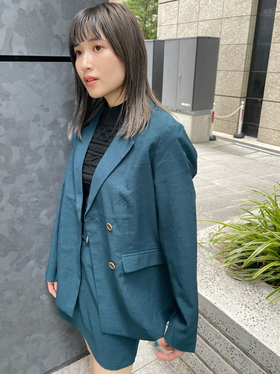 グリーン系のテーラードジャケット、グリーン系のスカート、ブラック系のニット/セーターを着用したレディースの夏コーディネートの7枚目の写真