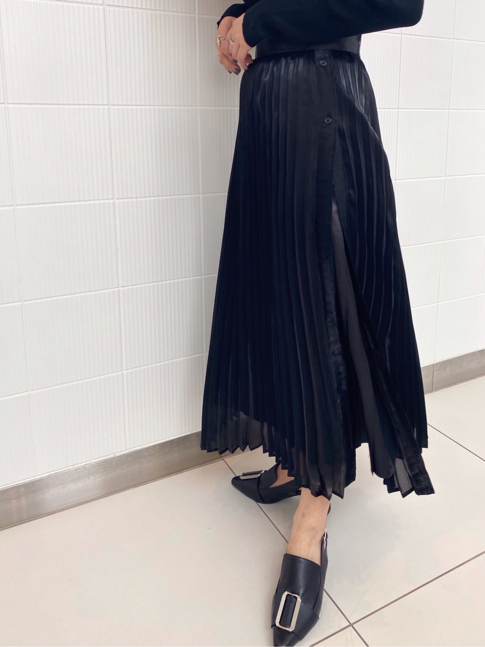 ブラック系のパンプス、ブラック系のニット/セーター、ブラック系のスカートを着用したレディースの春コーディネートの3枚目の写真