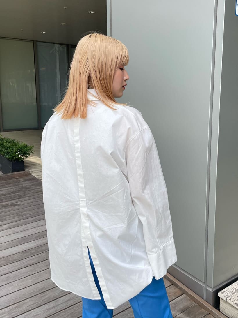 ベージュ系のスニーカー、ホワイト系のシャツ/ブラウス、ブルー系のスラックスを着用したレディースの春コーディネートの7枚目の写真