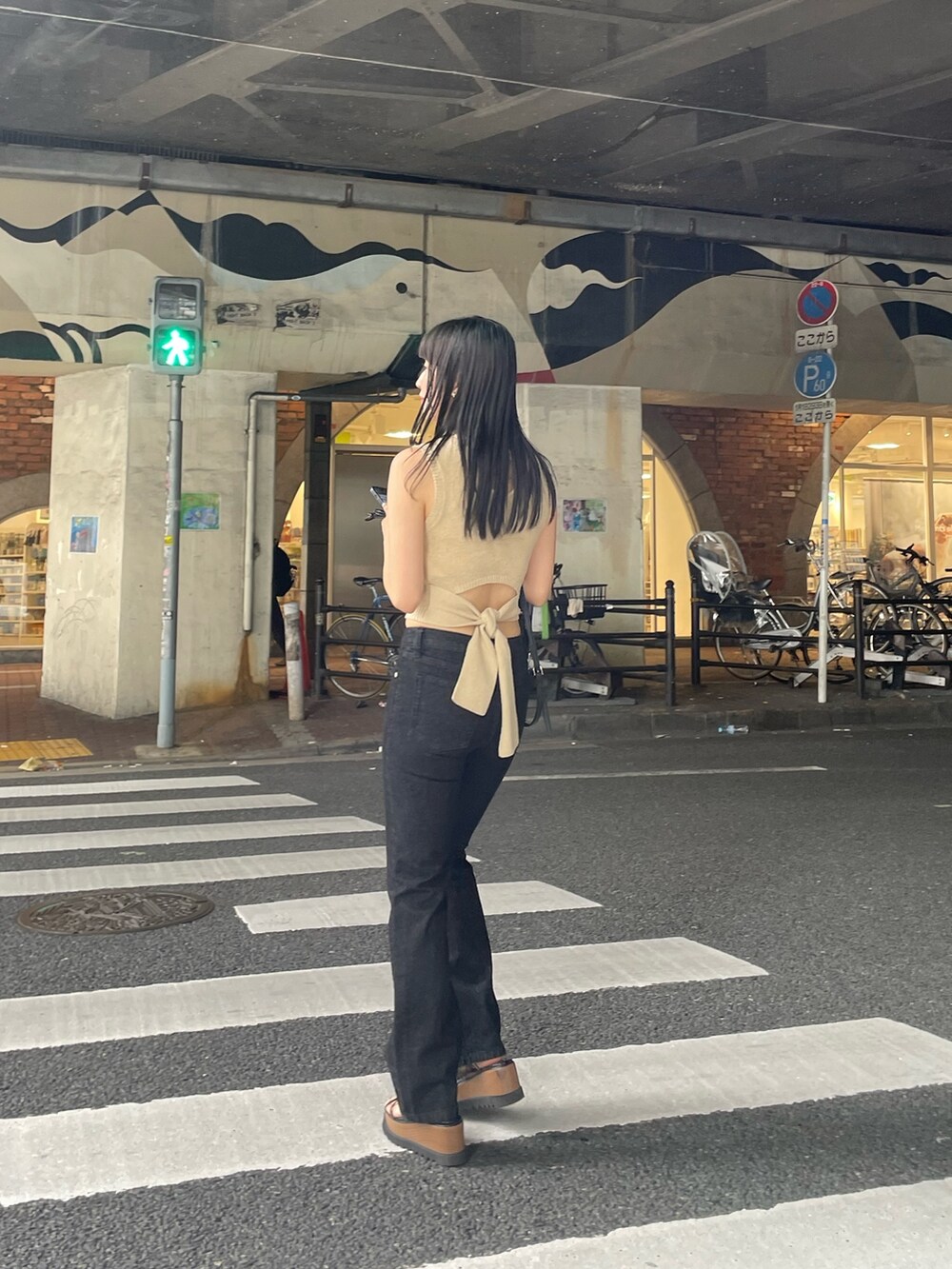 ホワイト系のタンクトップ、ブラック系のデニムパンツ、ブラック系のサンダルを着用したレディースの春コーディネートの5枚目の写真