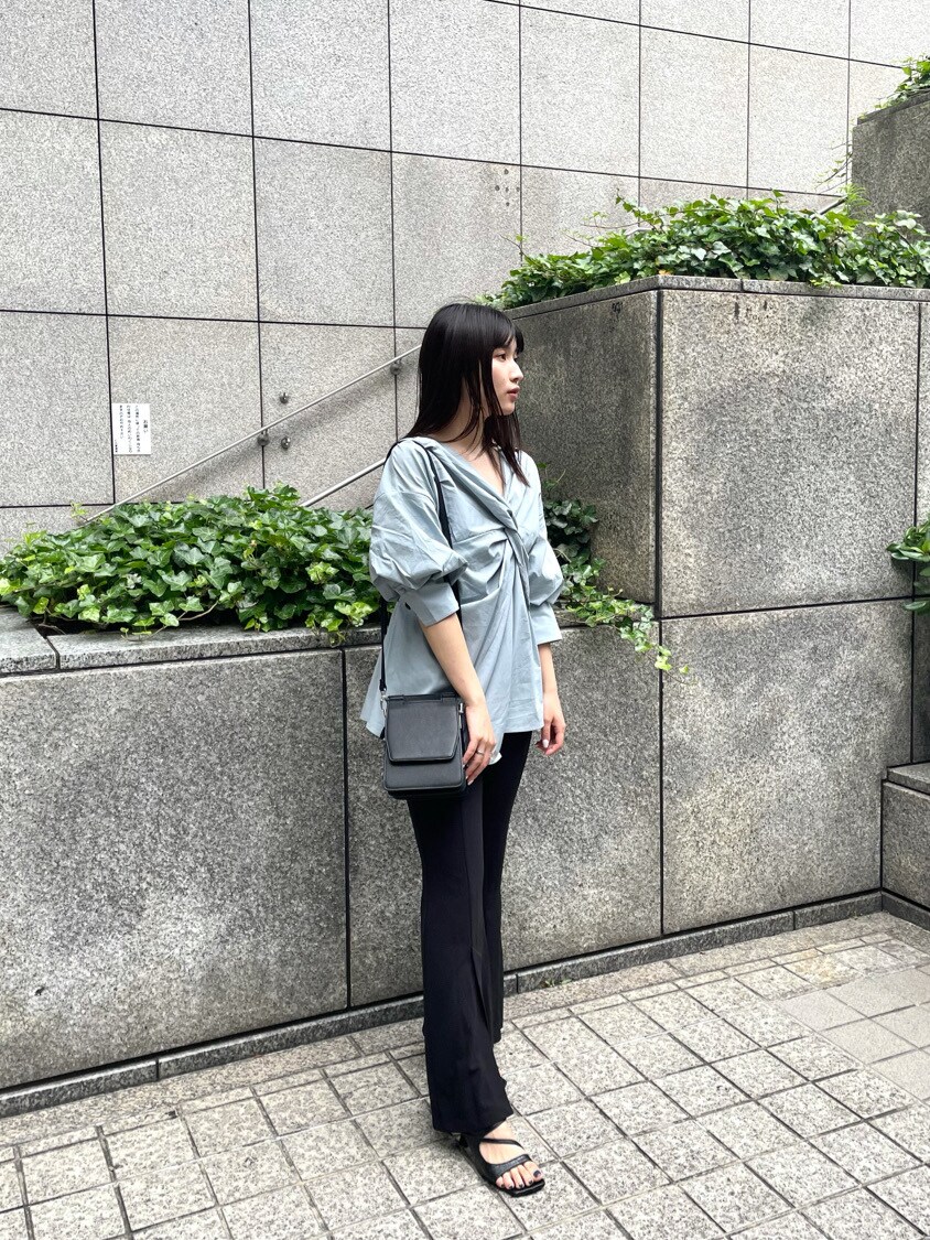 ブルー系のシャツ/ブラウス、ブラック系のサンダル、ブラック系のハンドバッグを着用したレディースの春コーディネートの2枚目の写真