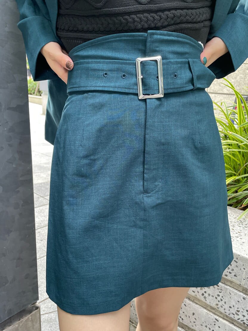 グリーン系のテーラードジャケット、グリーン系のスカート、ブラック系のニット/セーターを着用したレディースの夏コーディネートの8枚目の写真