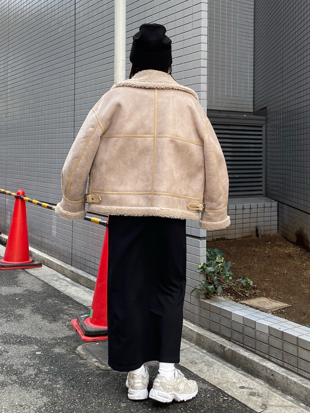 ベージュ系のムートンコート、パープル系のニット/セーター、ブラック系のスカートを着用したレディースの秋コーディネートの3枚目の写真