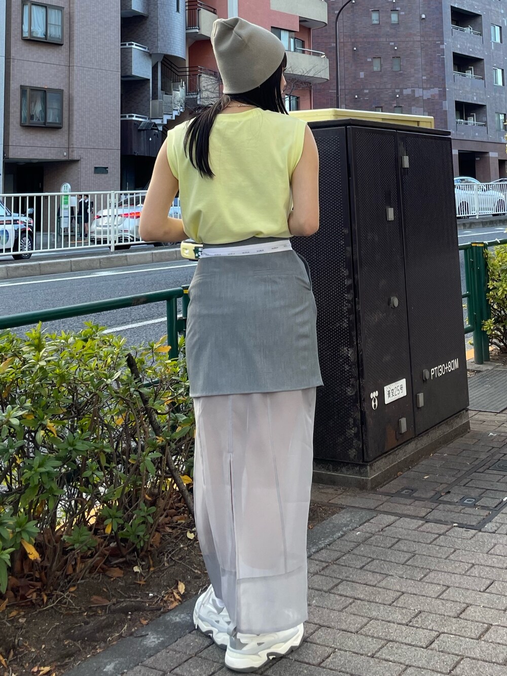 グレー系のスニーカー、イエロー系のタンクトップを着用したレディースの冬コーディネートの3枚目の写真