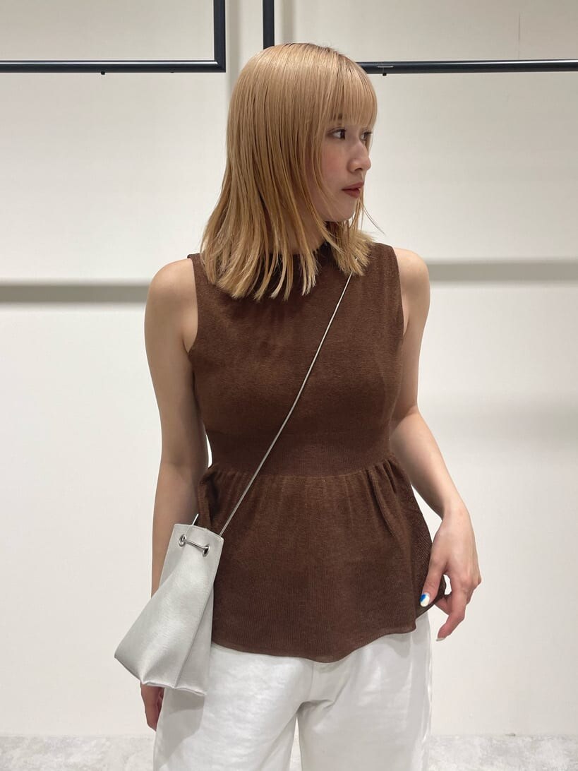 ホワイト系のデニムパンツ、ブラウン系のワンピース、ホワイト系のショルダーバッグを着用したレディースの春コーディネートの4枚目の写真