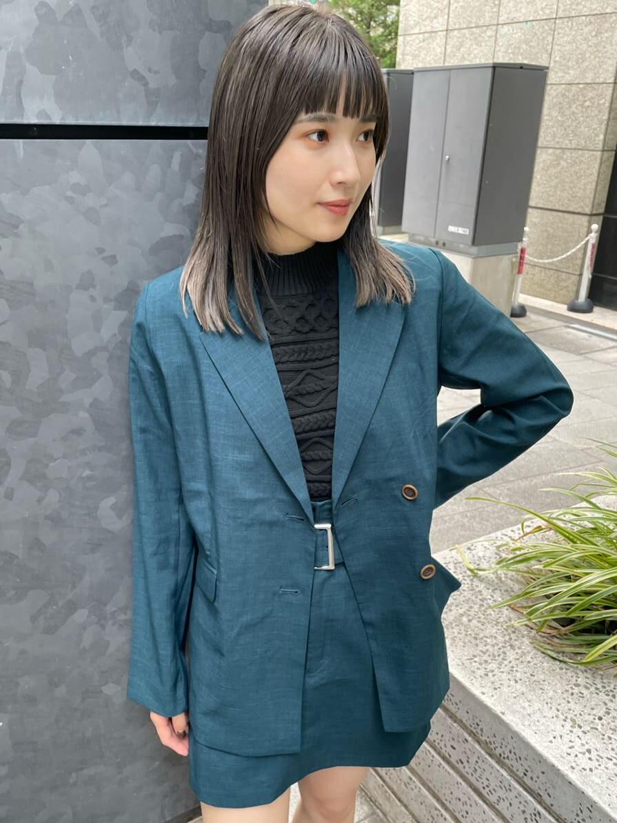 グリーン系のテーラードジャケット、グリーン系のスカート、ブラック系のニット/セーターを着用したレディースの夏コーディネートの6枚目の写真