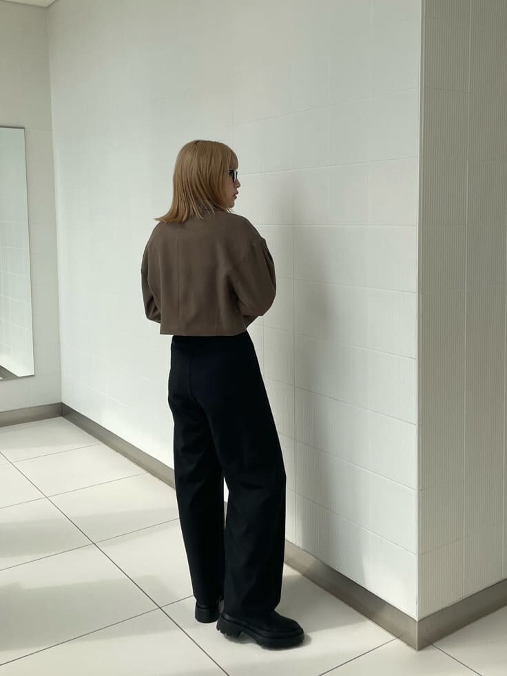 ブラック系のブーツ、ブラック系のスラックス、ブラウン系のテーラードジャケットを着用したレディースの春コーディネートの4枚目の写真