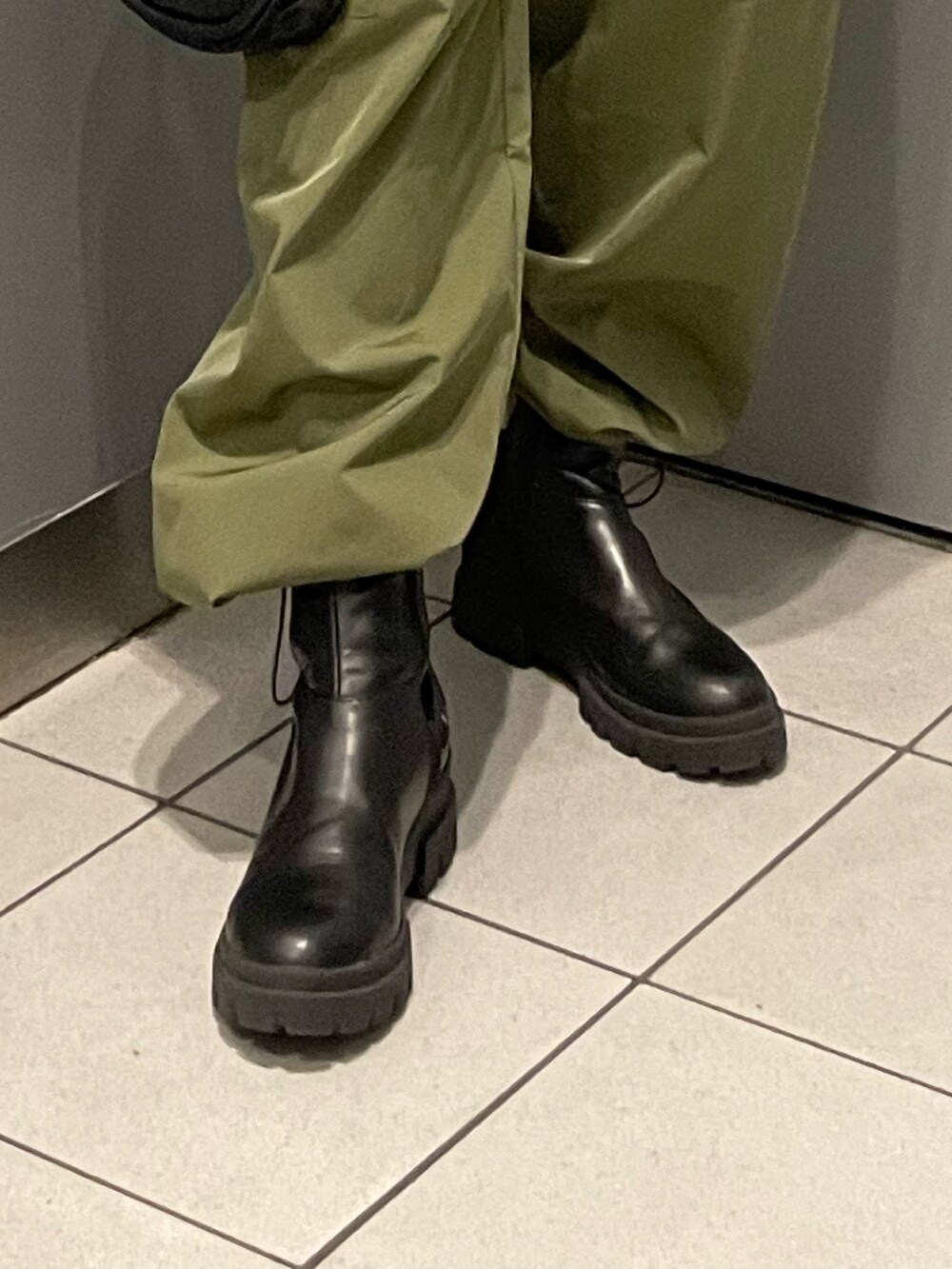 ブルー系のニット/セーター、ブラック系のハンドバッグ、ブラック系のブーツを着用したレディースの秋コーディネートの7枚目の写真