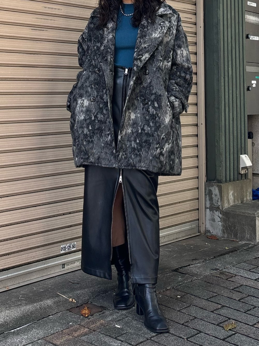 ブルー系のニット/セーター、ブラック系のその他アウター、ブラック系のスカートを着用したレディースの秋コーディネートの2枚目の写真