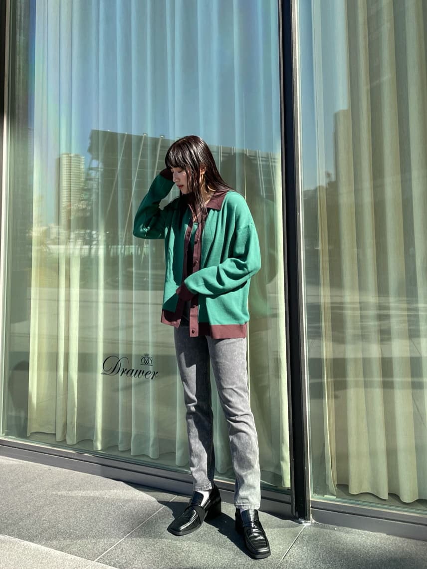 グリーン系のニット/セーター、グリーン系のカーディガン/ボレロ、ブラック系のデニムパンツを着用したレディースの秋コーディネートの2枚目の写真