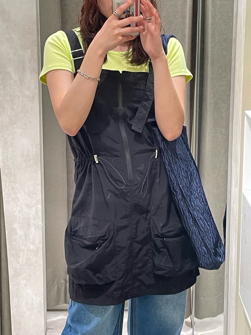 ブラック系のワンピース、ブルー系のデニムパンツ、ブラック系のサンダルを着用したレディースの春コーディネートの3枚目の写真