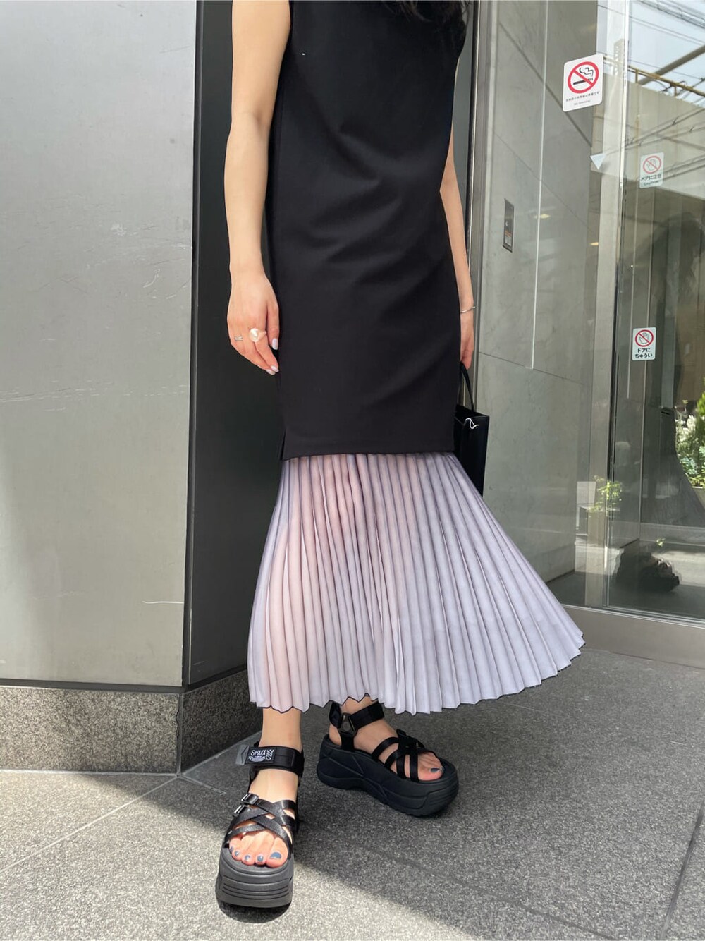 ブルー系のスカート、ブラック系のワンピース、ブラック系のサンダルを着用したレディースの夏コーディネートの5枚目の写真