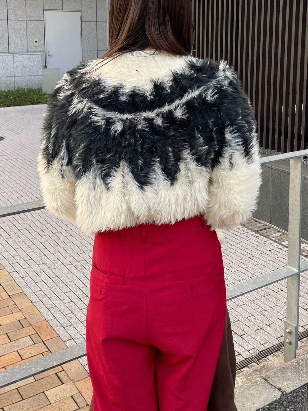 ホワイト系のニット/セーター、ブラウン系のムートンコートを着用したレディースの秋コーディネートの5枚目の写真