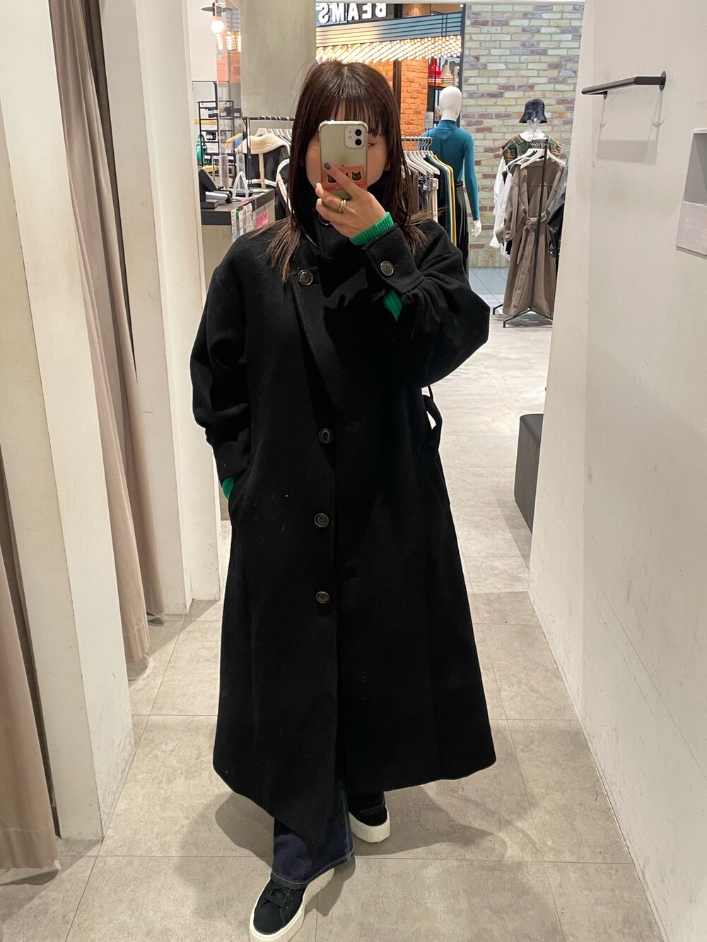 ブラック系のダウンジャケット/コート、グリーン系のニット/セーターを着用したレディースの冬コーディネートの4枚目の写真