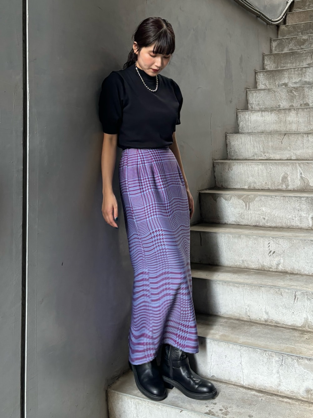 ブラック系のニット/セーター、パープル系のスカートを着用したレディースの夏コーディネートの3枚目の写真