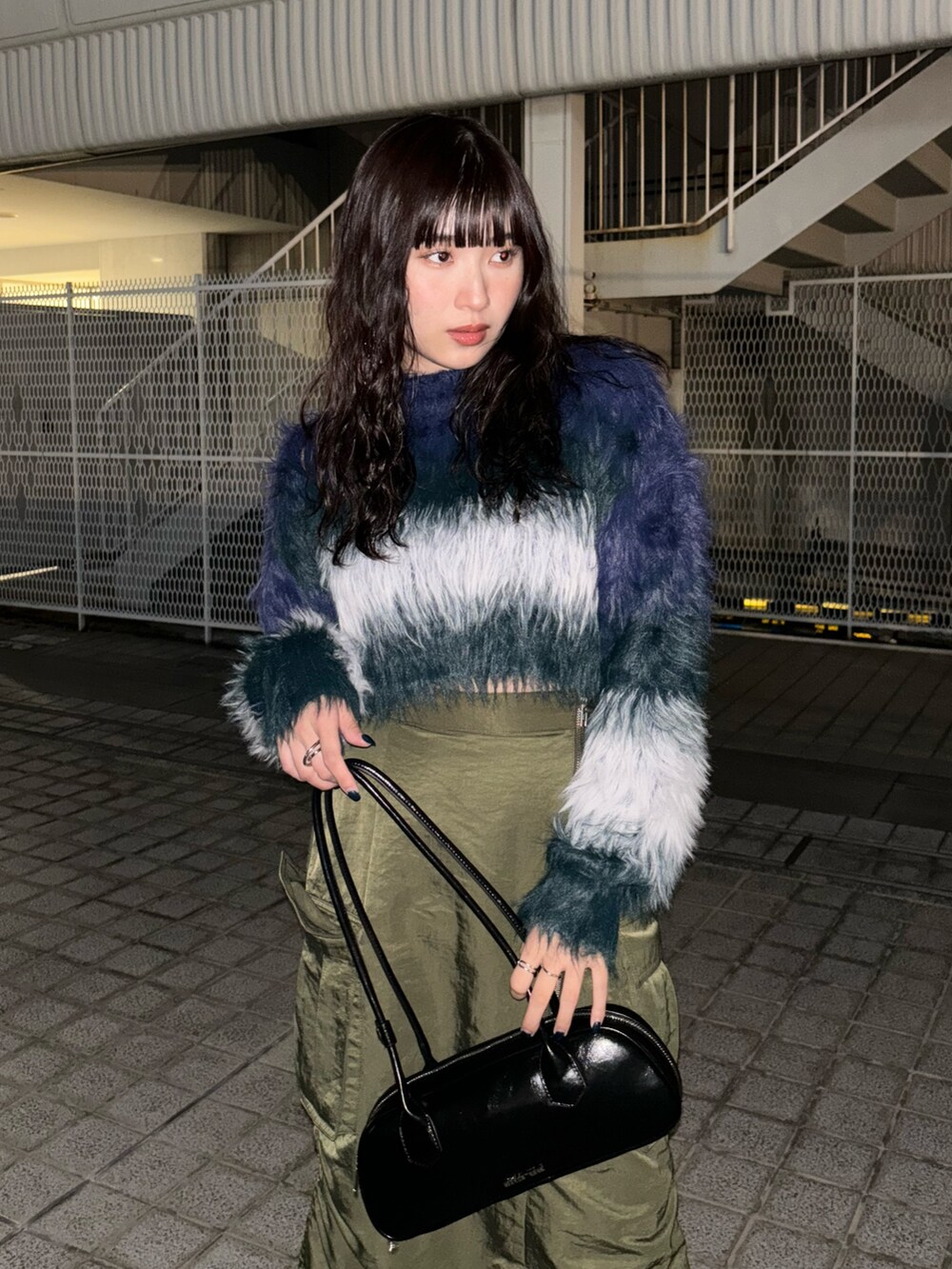 ブルー系のニット/セーター、グリーン系のスカート、ブラック系のブーツを着用したレディースの秋コーディネートの3枚目の写真