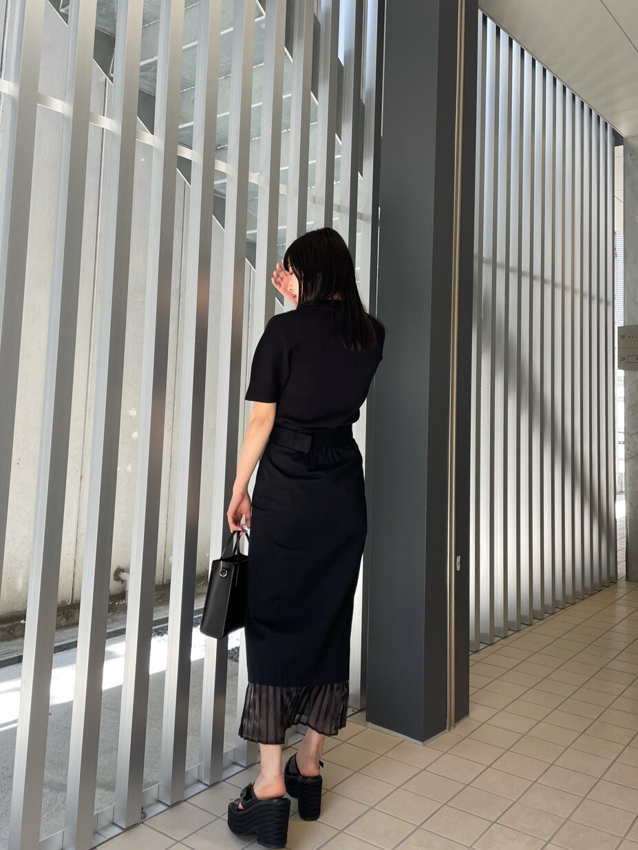 ブラック系のスカート、ブラック系のサンダル、ブラック系のニット/セーターを着用したレディースの春コーディネートの3枚目の写真