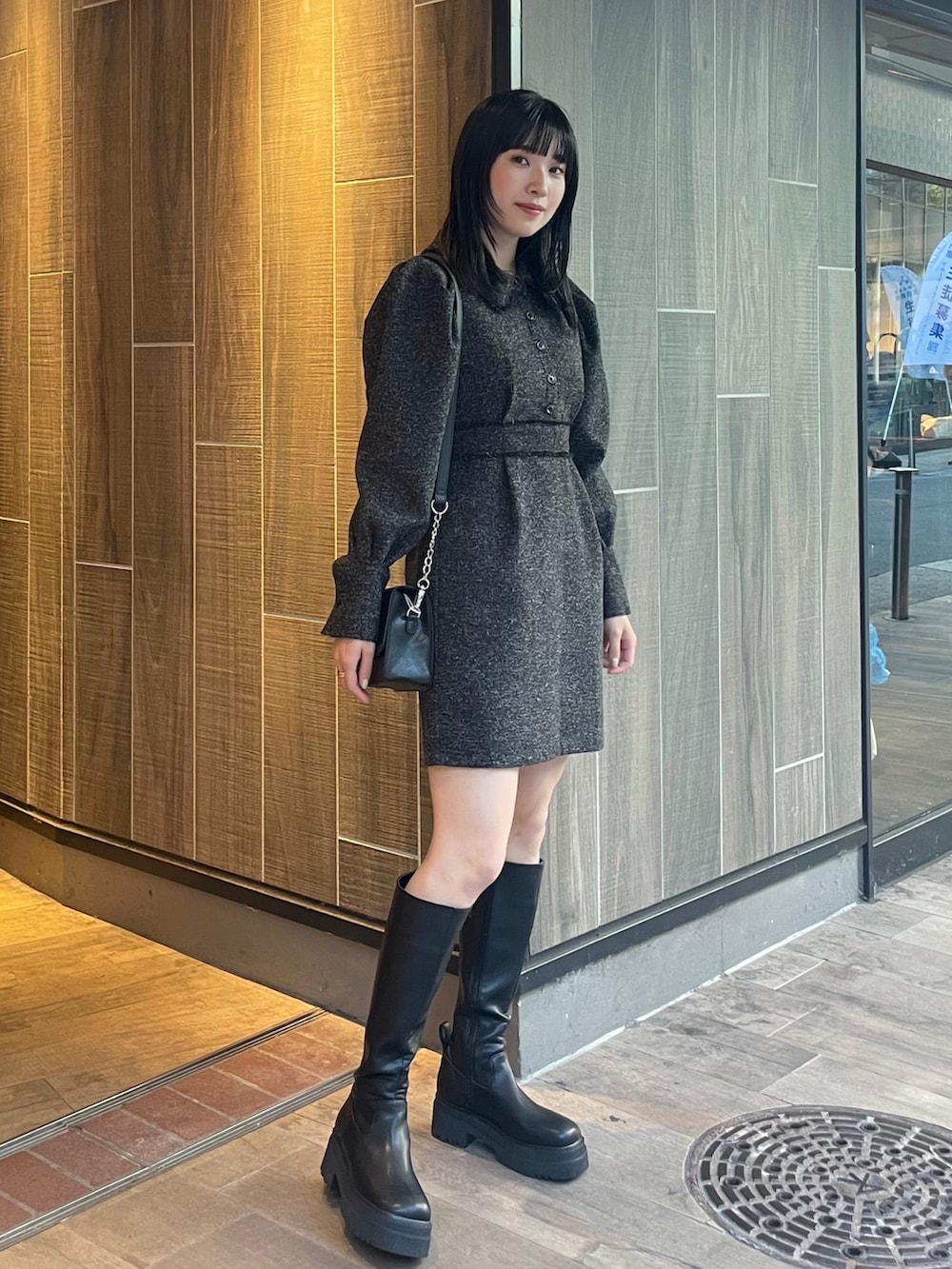 ブラック系のワンピース、ブラック系のブーツ、ブラック系のショルダーバッグを着用したレディースの冬コーディネートの2枚目の写真