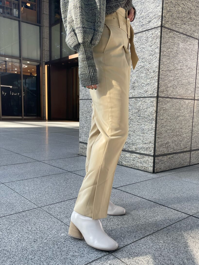 ホワイト系のブーツ、イエロー系のスラックス、ブラウン系のニット/セーターを着用したレディースの冬コーディネートの5枚目の写真