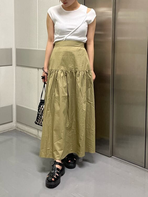 ブラック系のハンドバッグ、ブラック系のサンダル、ホワイト系のタンクトップを着用したレディースの夏コーディネートの2枚目の写真