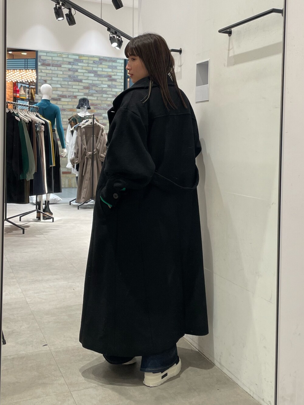 ブラック系のダウンジャケット/コート、グリーン系のニット/セーターを着用したレディースの冬コーディネートの3枚目の写真