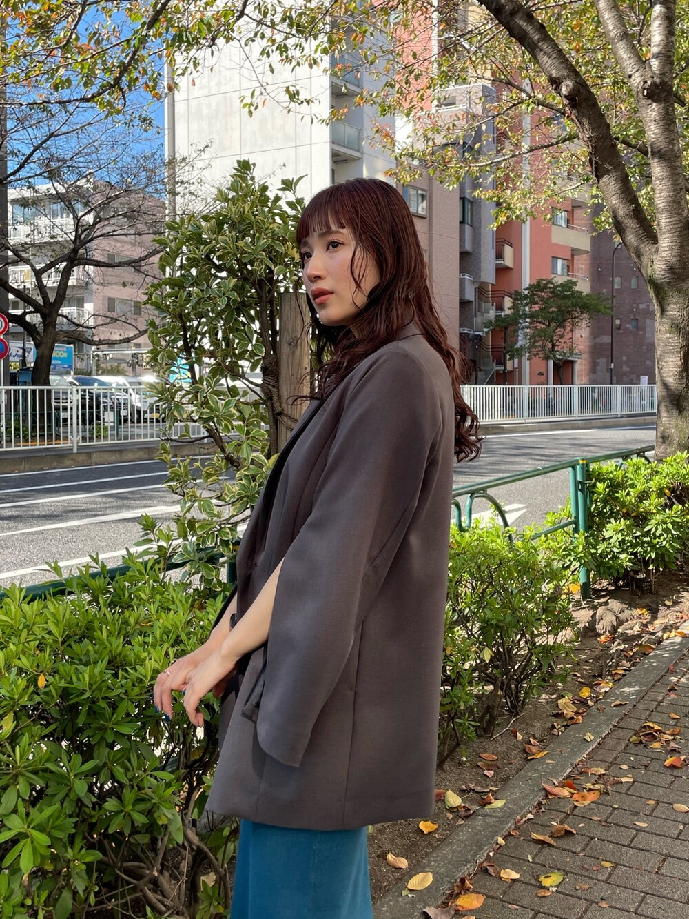 グレー系のテーラードジャケット、ブルー系のワンピースを着用したレディースの冬コーディネートの2枚目の写真