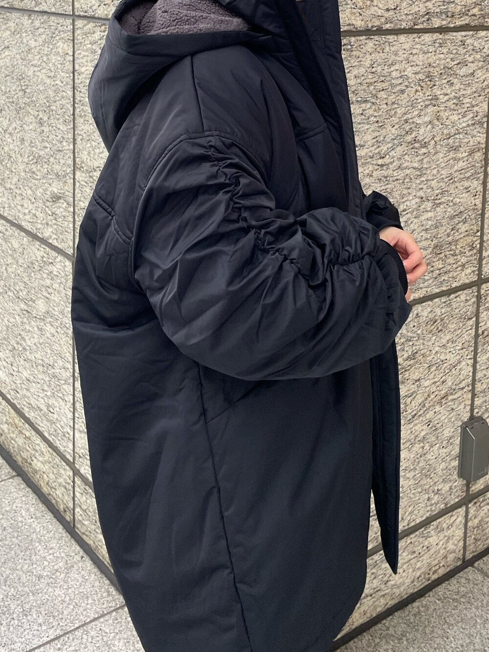 ブルー系のニット/セーター、ブラック系のブルゾンを着用したレディースの秋コーディネートの7枚目の写真