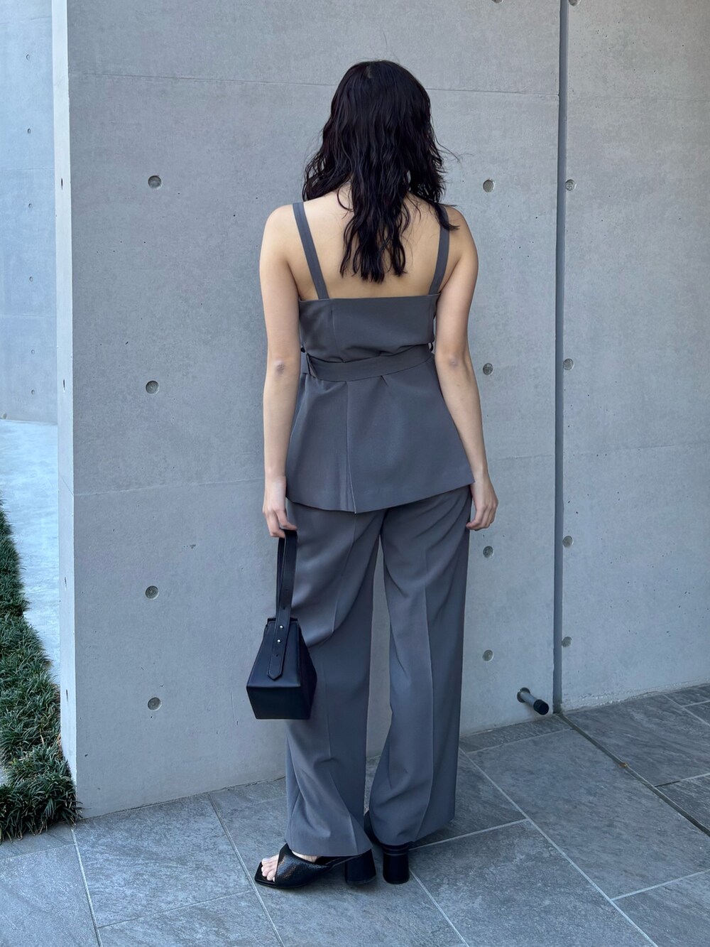 グレー系のベスト、グレー系のスラックスを着用したレディースの冬コーディネートの2枚目の写真