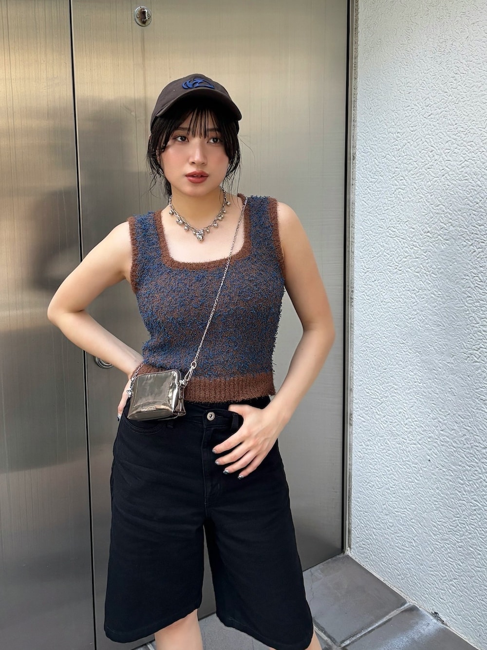 ゴールド系のショルダーバッグ、ブラウン系のニット/セーターを着用したレディースの夏コーディネートの2枚目の写真