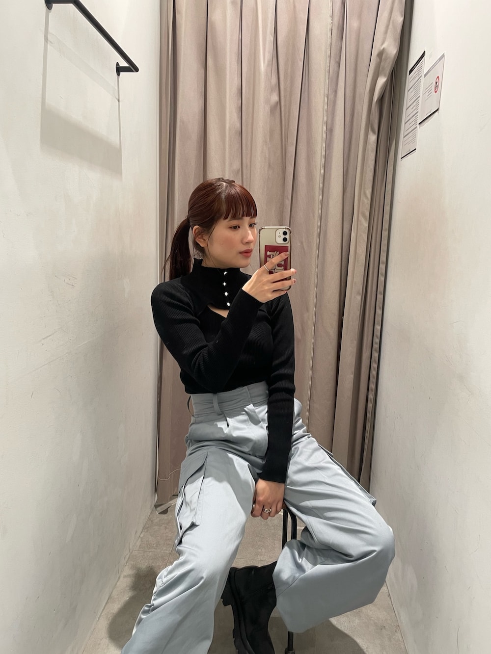 ブラック系のニット/セーター、ブルー系のカーゴパンツ、ブラック系のブーツを着用したレディースの冬コーディネートの3枚目の写真