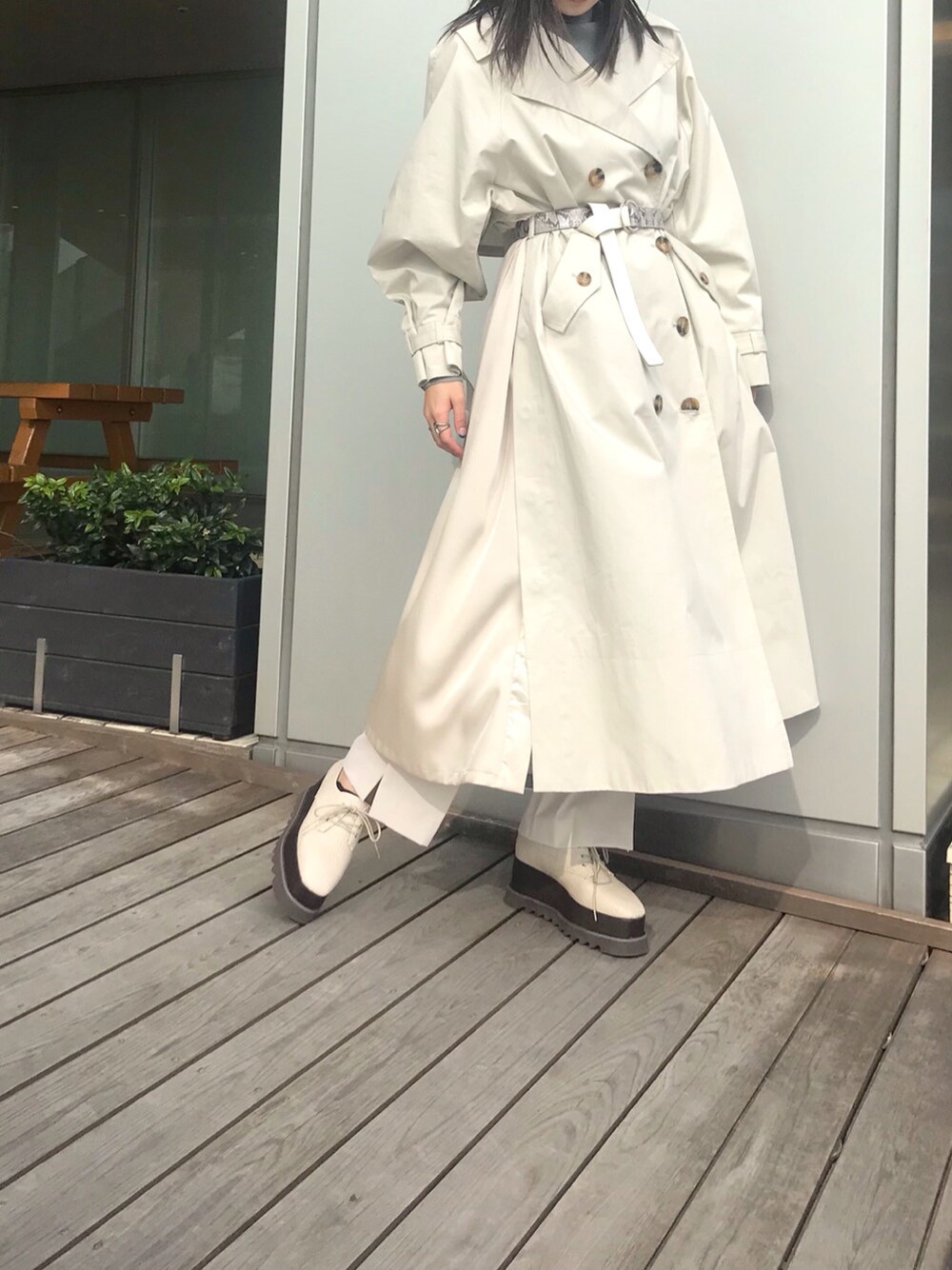 グリーン系のニット/セーター、ホワイト系のトレンチコート、ホワイト系のローファーを着用したレディースの冬コーディネートの3枚目の写真