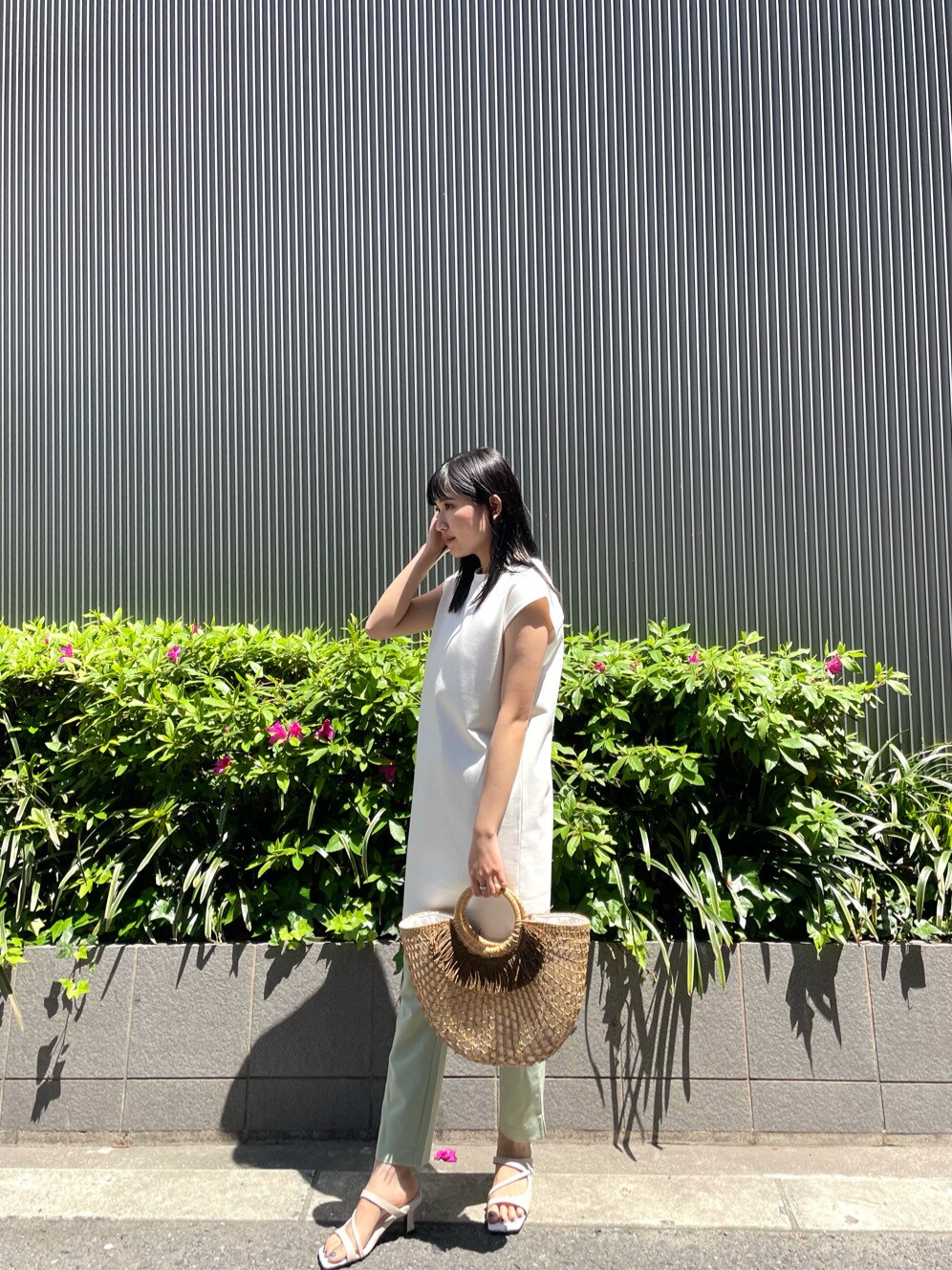 ホワイト系のワンピース、ホワイト系のサンダル、ベージュ系のかごバッグを着用したレディースの春コーディネートの2枚目の写真