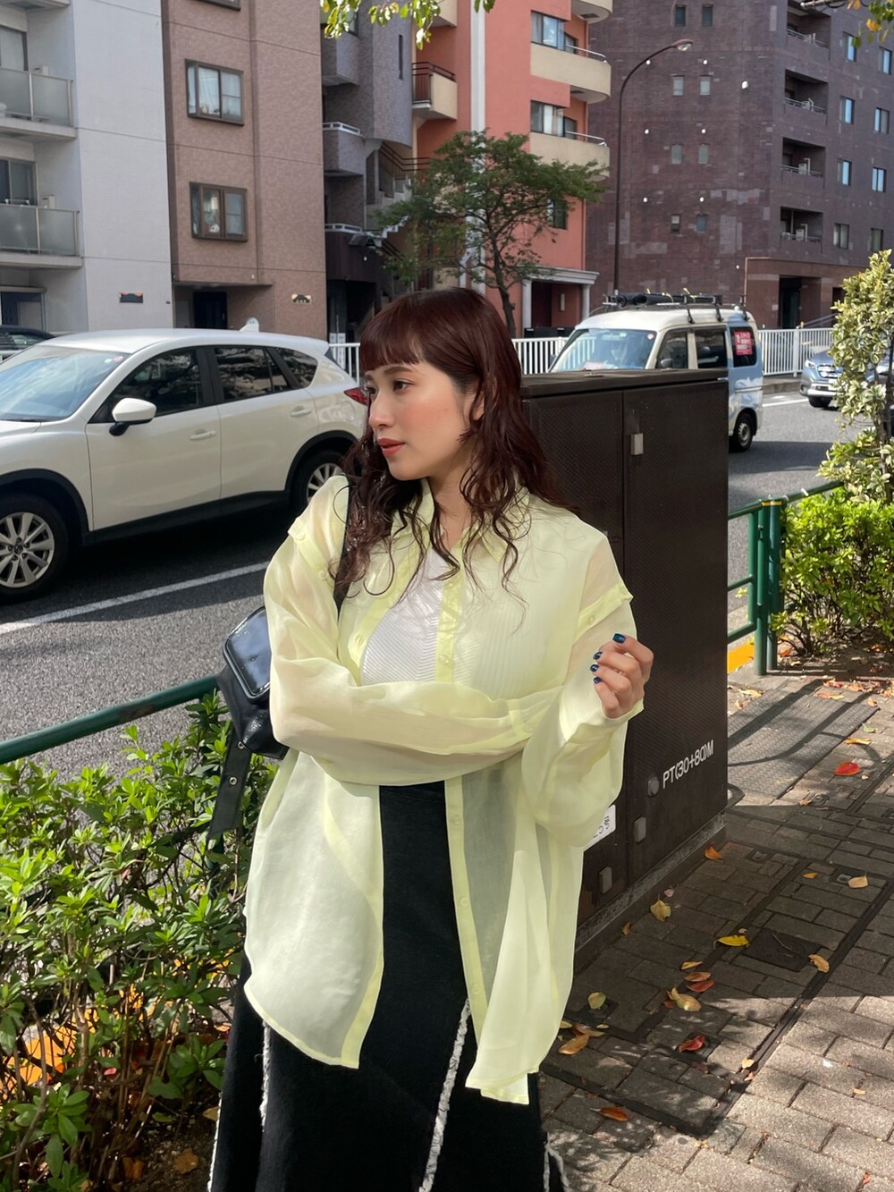 イエロー系のシャツ/ブラウス、ブラック系のデニムスカートを着用したレディースの冬コーディネートの3枚目の写真