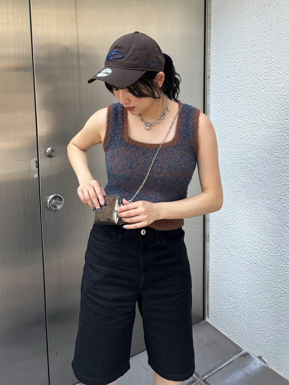 ゴールド系のショルダーバッグ、ブラウン系のニット/セーターを着用したレディースの夏コーディネートの3枚目の写真