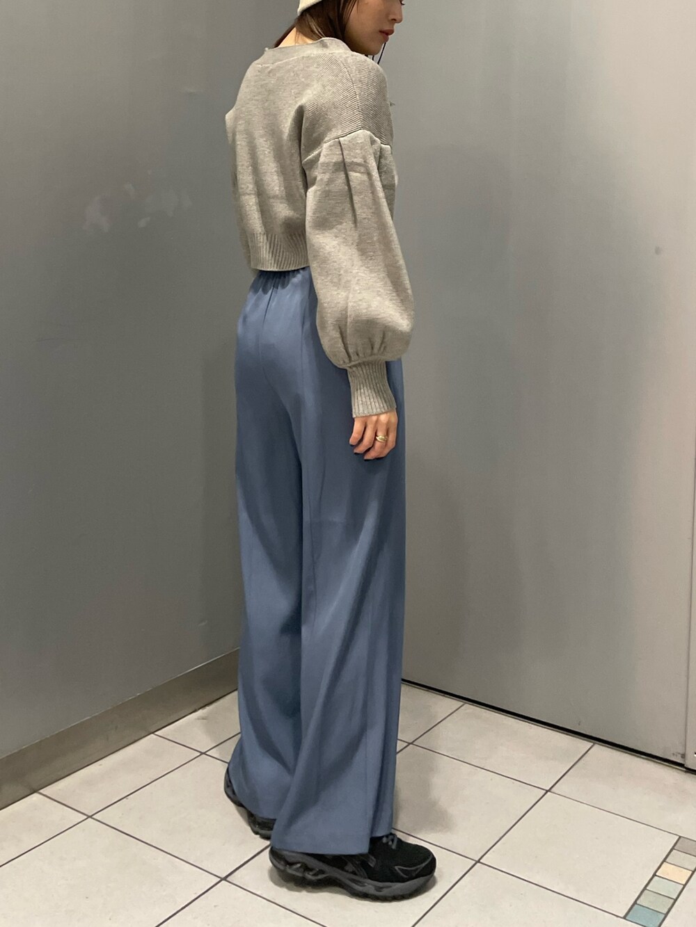 グレー系のカーディガン/ボレロ、ブルー系のスラックスを着用したレディースの冬コーディネートの2枚目の写真