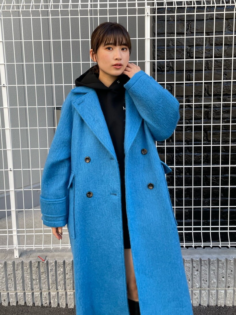 ブラック系のブーツ、ブラック系のパーカー、ブルー系のチェスターコートを着用したレディースの秋コーディネートの3枚目の写真