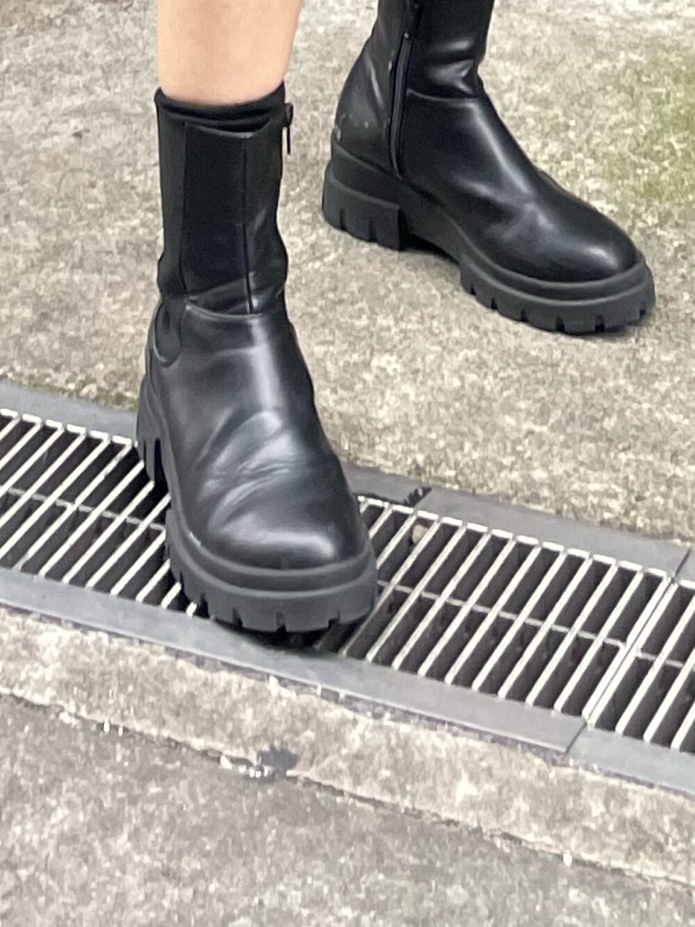 ホワイト系のブルゾン、ブラック系のワンピース、ブラック系のブーツを着用したレディースの冬コーディネートの8枚目の写真