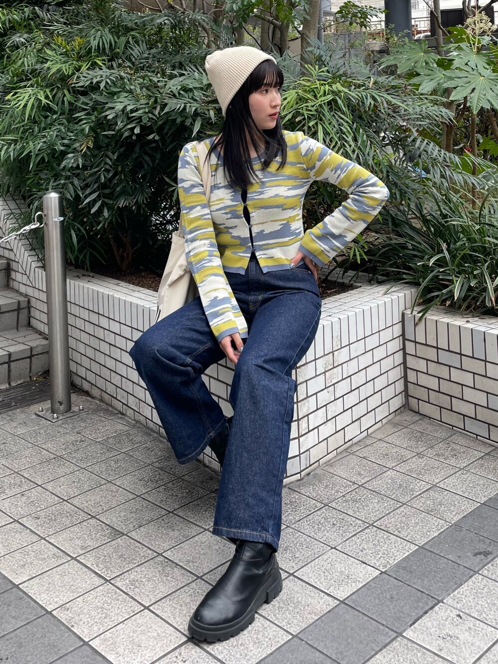 ブルー系のデニムパンツ、イエロー系のカーディガン/ボレロを着用したレディースの冬コーディネートの2枚目の写真