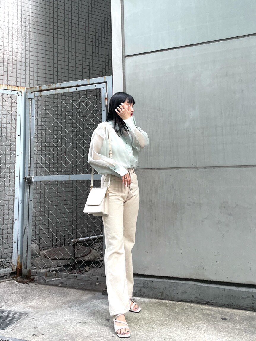 ホワイト系のその他パンツ、ホワイト系のハンドバッグ、ホワイト系のサンダルを着用したレディースの春コーディネートの2枚目の写真