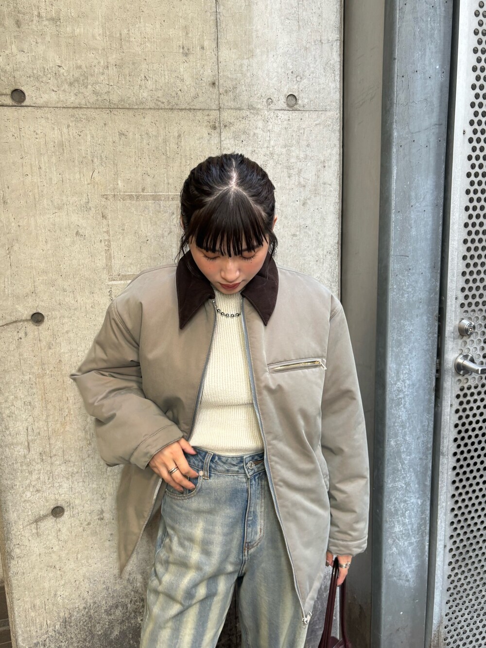 ベージュ系のブルゾン、ブルー系のデニムパンツを着用したレディースの秋コーディネートの4枚目の写真