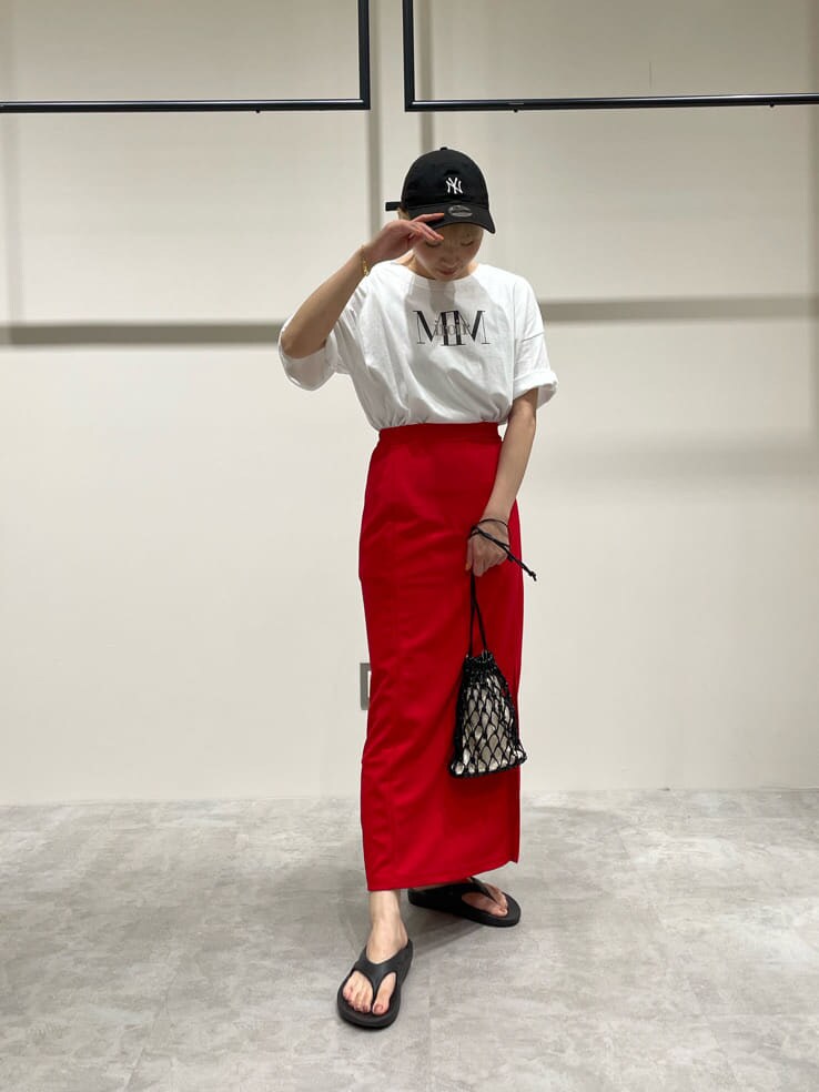 ブラック系のハンドバッグ、ホワイト系のTシャツ/カットソー、レッド系のスカートを着用したレディースの夏コーディネートの2枚目の写真