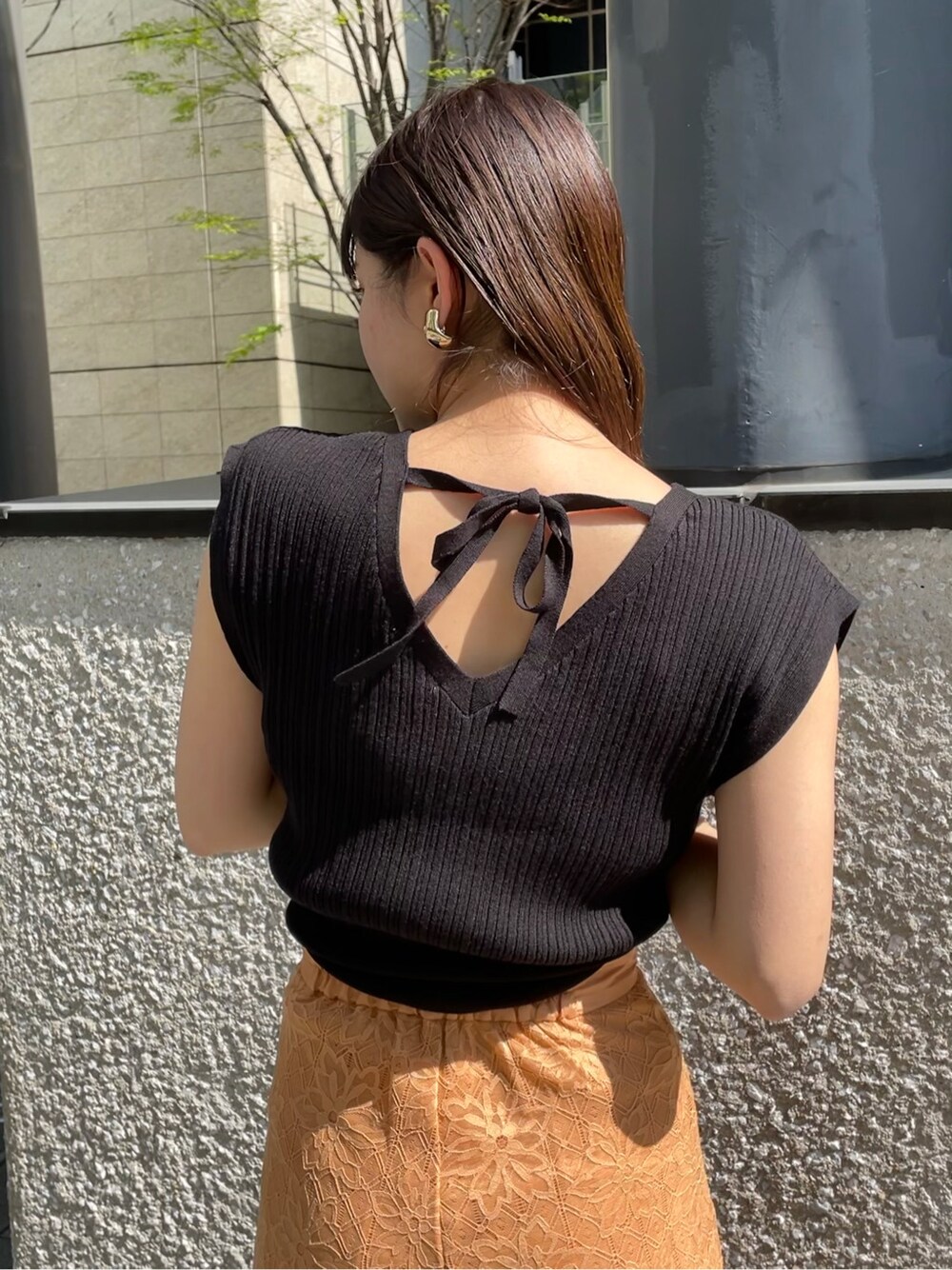 オレンジ系のその他パンツ、ブラック系のサンダル、ブラック系のニット/セーターを着用したレディースの春コーディネートの4枚目の写真