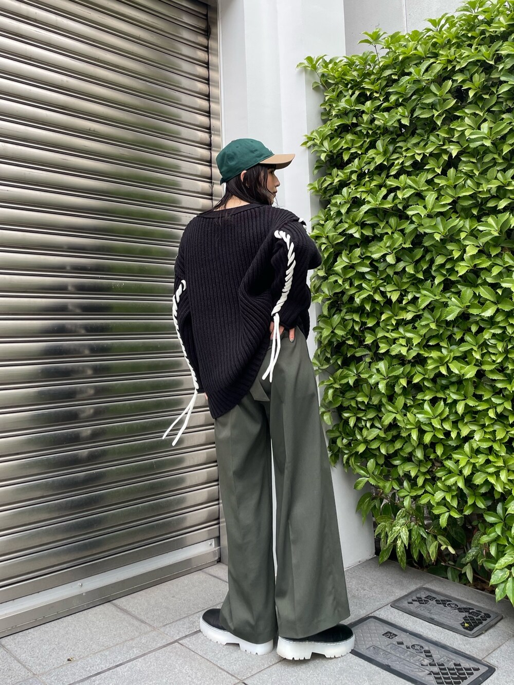 ベージュ系のスラックス、ブラック系のカーディガン/ボレロ、グリーン系のキャップを着用したレディースの秋コーディネートの6枚目の写真