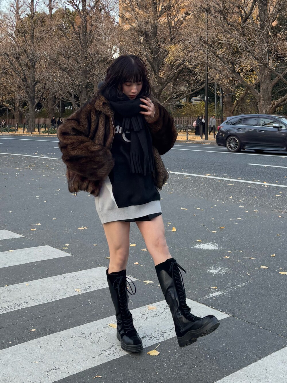 ブラウン系のブルゾン、ブラック系のワンピース、ブラック系のブーツを着用したレディースの冬コーディネートの3枚目の写真