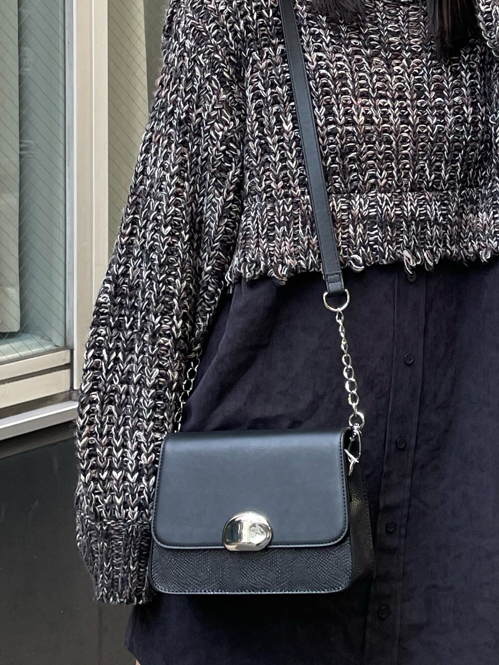 ブラック系のワンピース、ブラック系のブーツ、ブラック系のショルダーバッグを着用したレディースの秋コーディネートの6枚目の写真