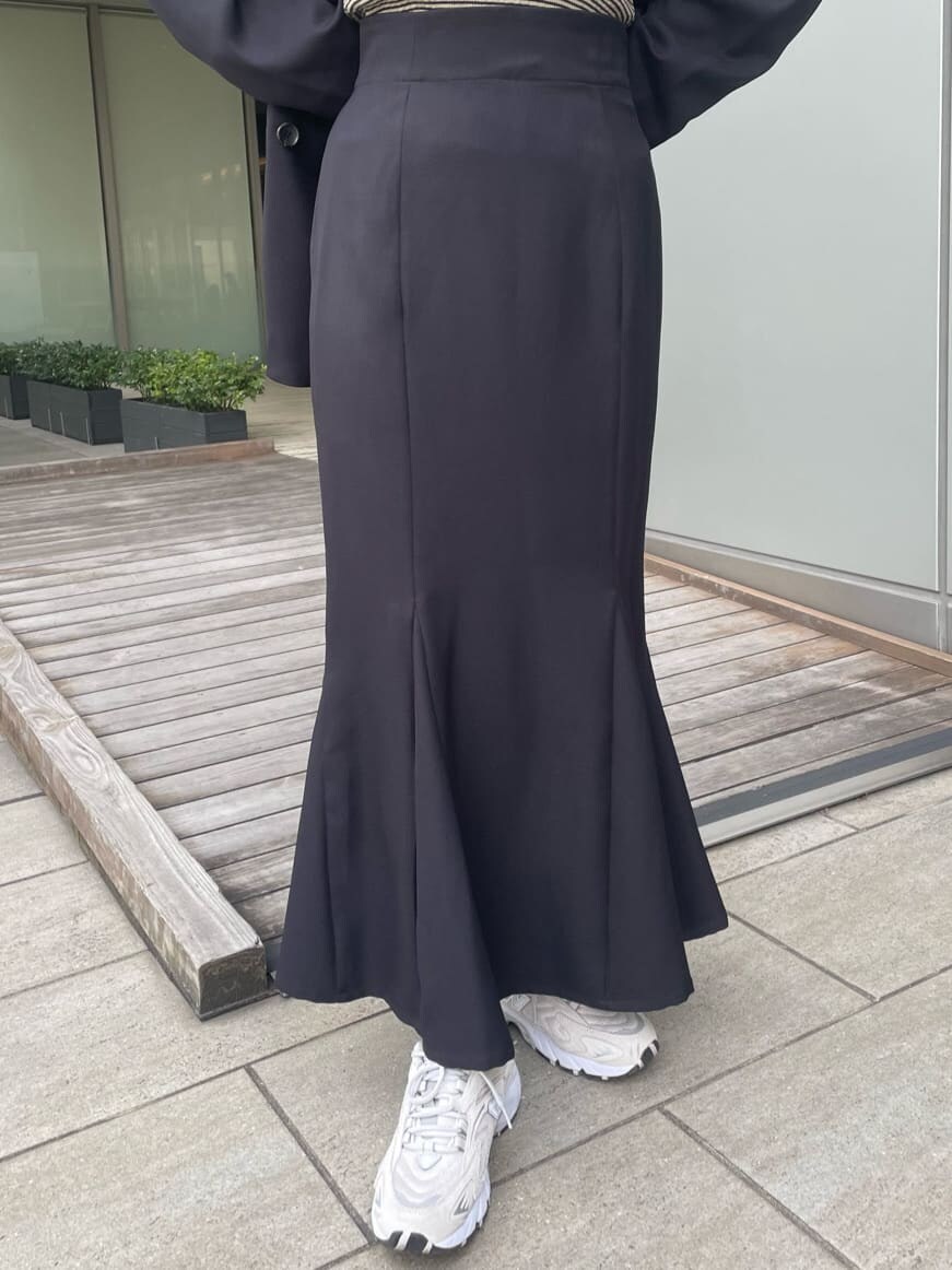 ブラック系のテーラードジャケット、ホワイト系のハンドバッグ、ブラック系のスカートを着用したレディースの春コーディネートの7枚目の写真